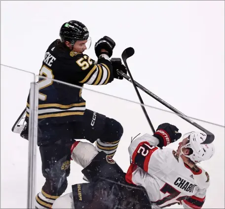  ?? STAFF PHOTO — STUART CAHILL/BOSTON HERALD ?? Boston Bruins defenseman Andrew Peeke, left, levels Ottawa Senators defenseman Thomas Chabot during Tuesday’s regular-season finale at the TD Garden. The Bruins fell, 3-1.