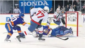  ??  ?? The Capitals’ TJ Oshie scores against the Islanders.