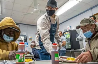  ?? Steph Chambers/Post-Gazette ?? Pirates bench coach Don Kelly serves meals Friday at Light of Life Rescue Mission on the North Side. “It’s something that’s always been important to us, to be able to give back in that way,” Kelly, a Mt. Lebanon native, said of him and his wife, Carrie.