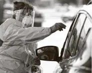  ?? Melissa Phillip / Staff photograph­er ?? Debbie Veselka, a Kroger pharmacy practice coordinato­r, gives a driver a self-testing kit Tuesday.