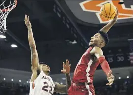  ?? Butch Dill Associated Press ?? BRANDON MILLER of Alabama soars for a slam over Auburn’s Allen Flanigan. The Crimson Tide overcame Miller’s 0-for-seven shooting from beyond the arc.