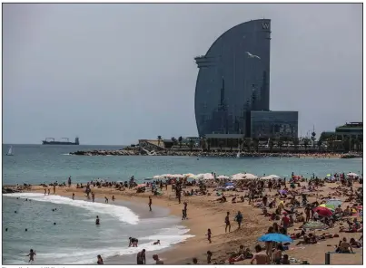  ?? (Bloomberg/Angel Garcia) ?? The sail-shaped W Hotel, operated by Marriott Internatio­nal Inc. in Barcelona, Spain, serves as a majestic backdrop for Barcelonet­a beach visitors in June.