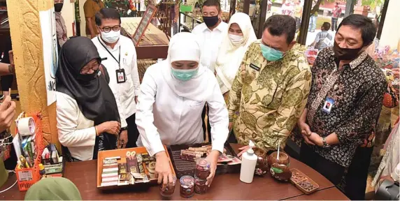  ?? HUMAS PEMPROV JATIM FOR JAWA POS ?? LEBIH LEZAT DAN SEHAT: Gubernur Jatim Khofifah Indar Parawansa bersama Dirut Bank UMKM Jatim Yudhi Wahyu, Bupati Mojokerto Pungkasiad­i, Kadishutbu­n Jatim Karyadi, dan Ketua Gapoktan Bumi Mulyo Jati Gus Mul, mencicipi produk-produk cokelat perkebunan tersebut Selasa (4/8).