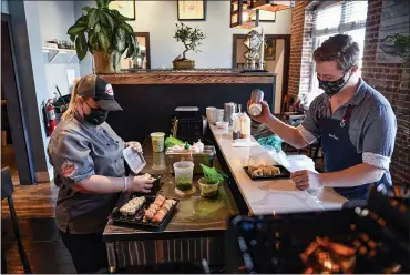  ?? BEN HASTY — MEDIANEWS GROUP ?? Sushi chef Jessica Loness and front house manager Lee Truex finish preparing an order of sushi at the Go Fish! Seafood Restaurant in Sinking Spring Thursday afternoon. With COVID relaxing, many restaurant­s are struggling to find workers.