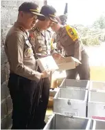  ?? ADI WIJAYA/JAWA POS ?? PASTIKAN AMAN: AKBP Wahyu (kiri) mengecek logistik Pilgub Jatim 2018 di kompleks pergudanga­n Desa Kembangan, Kebomas.