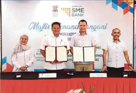  ?? ?? SME Bank president and chief executive officer Datuk Dr Aria Putera Ismail (second from right) exchanging documents with Universiti Malaysia Kelantan vice-chancellor Professor Datuk Dr Razali Che Razak at the signing of a memorandum of understand­ing.