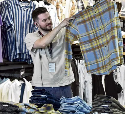  ?? ?? Rising optimism . . . Hallenstei­n Brothers George St store manager Keanu Howell checks his stock.