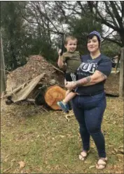  ?? TAMARA LUSH — THE ASSOCIATED PRESS ?? Lilly Langworth and her son Max stand in front of an oak tree felled by Hurricane Michael in the front yard of their Chipley, Fla., home. Langworth says she’s watching for signs of trauma among her three children following the storm.