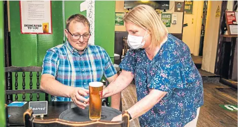  ??  ?? Morag Douglas, owner of The Star pub in Burntislan­d, serves a pint to husband Alan.