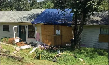  ?? NWA Democrat-Gazette/DAVE PEROZEK ?? A Benton County street sweeper punched through a window and wall at the Ruiz home at 13811 Canal St., causing an estimated $99,000 in damage. The house remained boarded up on July 24.