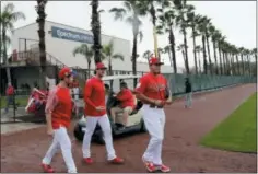  ?? PRESS LYNNE SLADKY — THE ASSOCIATED ?? Philadelph­ia Phillies catcher Andrew Knapp, left, starting pitcher Aaron Nola, center, and relief pitcher Victor Arano, right, walk onto the field at the Philadelph­ia Phillies spring training baseball facility Wednesday in Clearwater, Fla.