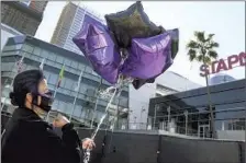  ?? Wally Skalij Los Angeles Times ?? JOSIE ALVAREZ makes the sign of the cross before releasing balloons across from the Lakers’ arena in downtown Los Angeles.
