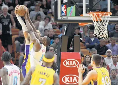  ?? JIM RASSOL/STAFF PHOTOGRAPH­ER ?? Miami’s Bam Adebayo (13) blocks the dunk attempt of Los Angeles forward Kyle Kuzma on this first half play Thursday night during Los Angeles’ victory.