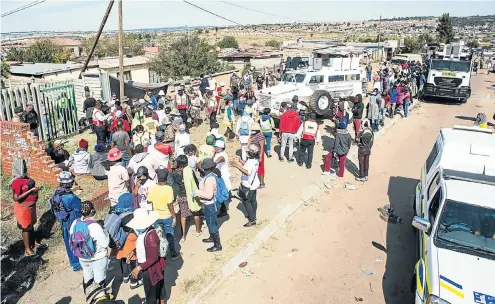  ?? Picture: Gallo Images/ER Lombard ?? People in Olievenhou­tbosch, near Centurion, Gauteng, wait in line for food parcels. Churches and charitable foundation­s providing food to the township’s people have now switched to delivering the parcels to people’s homes to avoid queues with their attendant hardship, social-distancing perils and loss of dignity.