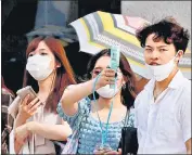  ?? REUTERS ?? Pedestrian­s uses a portable fan on the street during a heatwave in Tokyo, Japan.