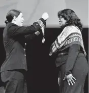  ?? PAUL W. GILLESPIE/CAPITAL GAZETTE ?? Midshipman 1c and Brigade Commander Lindsey E. Ellison, left, presents Distinguis­hed Graduate Janie L. Mines with her award medal Friday night.