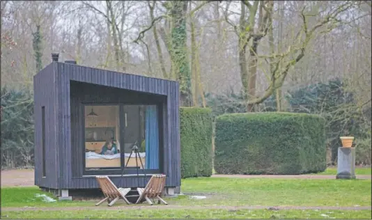  ??  ?? Kim Devos reads a book in a Slow Cabin in Elewijt, Belgium. These Slow Cabins, set up the Belgian countrysid­e, provide a way to vacation in pandemic times: in complete solitude and in the middle of nowhere.
(AP/Virginia Mayo)