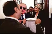  ?? AP ?? An aide of Lebanon’s Grand Mufti Shaikh Abdul Latif Derian (left) gives a headscarf to Marine Le Pen to wear during her meeting with the Mufti but she refused.