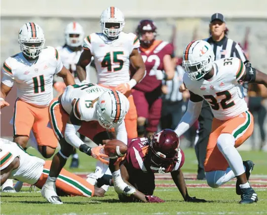  ?? MATT GENTRY/AP ?? Miami’s Avantae Williams (15) scoops up a fumble by Virginia Tech’s Dae’Quan Wright in the first half Saturday in Blacksburg, Virginia.