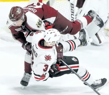  ?? CLIFFORD SKARSTEDT/PETERBOROU­GH EXAMINER ?? Peterborou­gh Petes' Austin Osmanski checks IceDogs' Ben Jones to the ice during first-period OHL action Monday at the Memorial Centre in Peterborou­gh.