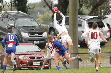  ?? ?? Right: Dusties player Kane Taylor flies for a mark in the match against Bunyip. Warragul Industrial­s would go on to win the match by 11 points.