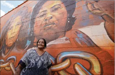 ?? (File Photo/AP/Rogelio V. Solis) ?? Jacqueline Hamer Flakes, the adoptive daughter of civil rights icon Fannie Lou Hamer, stands July 24 beneath the mural of her mother that was painted on the side of the Council of Federated Organizati­ons building in Jackson, Miss.