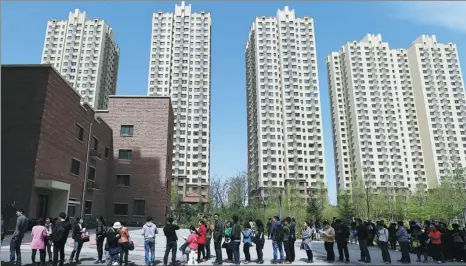  ?? WANG ZHUANGFEI /CHINA DAILY ?? People line up to apply for public rental housing in Chaoyang district. The apartments there range from 58 to 61 square meters with a monthly rent of 2,000 to 2,400 yuan. The authoritie­s have been trying to reduce rents.