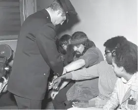  ?? Barney Peterson / The Chronicle 1967 ?? An officer handcuffs the Grateful Dead’s Ron “Pigpen” McKernan (center).