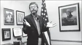  ?? AJC FILE PHOTO ?? Columnist Lewis Grizzard in a corner of his office sometime during the 1980s with a portrait of his hero John Wayne.