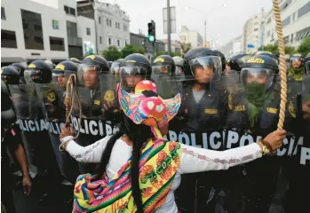  ?? MARTIN MEJIA/AP ?? An anti-government protester confronts police in Lima, Peru. Demonstrat­ors who gathered Thursday want immediate elections, the resignatio­n of President Dina Boluarte, the release of former President Pedro Castillo, who was arrested for trying to dissolve Congress in December, and justice for protesters killed in many previous clashes with police.