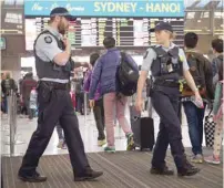  ?? — AFP ?? Police walk past passengers as they patrol Sydney Airport on Sunday.