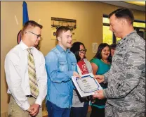  ?? JAMIE BURNETT/377TH AIR BASE WING ?? 58th Special Operations Wing Commander Col. Dagvin Anderson, right, gives an Honorary Warrior certificat­e to James Keefner, a student at Jeremiah’s Place, on Nov. 13 at Kirtland Air Force Base. The certificat­es were presented to eight students at the promotion ceremony for 58th SOW member 1st Lt. Eddie Cruz.