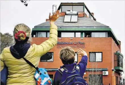  ??  ?? PARQUE BATLLE. Familiares de una internada saludan desde la vereda. Las autoridade­s de la salud analizan la razón del origen de los casos.