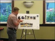  ?? NICHOLAS BUONANNO — NBUONANNO@TROYRECORD.COM ?? Chad Fowler, a spokesman for Stewart’s Shops, points out some of the historic designs that would be featured in the company’s proposed new location in the town of Brunswick during a Thursday night public hearing hosted by the town Planning Board.