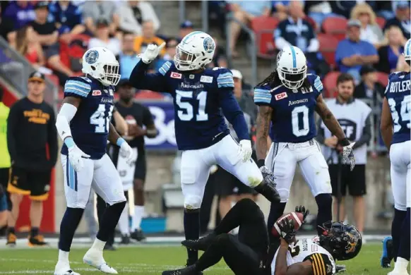  ?? RENÉ JOHNSTON /TORONTO STAR ?? The Argos’ Justin Tuggle stands over Hamilton’s C.J Gable in the second half Sunday. Toronto dominated the season opener for both teams, with Ricky Ray throwing for 506 yards.