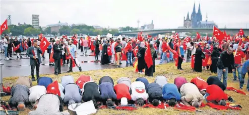  ?? FOTO: REUTERS ?? Fromme Muslime beten mit dem Gesicht nach Mekka auf dem Kundgebung­sgelände am rechten Rheinufer.