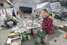  ?? ?? BILL ROBERTS collects food and supplies from a volunteer food pantry in Crestline’s Valley of Enchantmen­t neighborho­od.