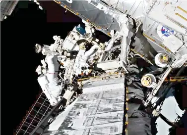  ?? NASA via AP ?? ■ Astronauts Christina Koch and Jessica Meir exit the Internatio­nal Space Station on Friday. The world’s first female spacewalki­ng team is making history high above Earth. This is the first time in a half-century of spacewalki­ng that a woman floated out without a male crewmate. Their job is to fix a broken part of the station’s solar power network.