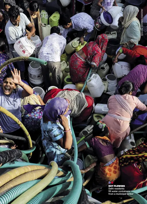  ??  ?? NOT FLOWING
Delhi residents fill water containers from a municipal tanker