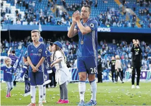  ?? IAN KINGTON/ AFP ?? Chelsea’s John Terry applauds alongside his kids after Sunday’s final league match against Sunderland. /