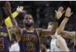  ?? ELISE AMENDOLA — THE ASSOCIATED PRESS ?? Cleveland Cavaliers forward LeBron James trades high-fives with teammates Iman Shumpert, left, and Deron Williams, right, during the first half of Game 2 of the NBA basketball Eastern Conference finals against the Boston Celtics on Friday in Boston.