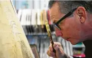  ?? Annie Mulligan / Contributo­r ?? Ed Grusnis, owner of the Antiquariu­m in River Oaks, studies one of the original maps of Houston.