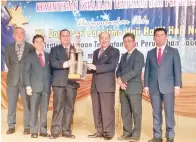  ??  ?? PEGAWAI Kerja Majlis Daerah Penampang Tang Yang Ming (tiga kiri) menerima Piala Pusingan Menteri daripada Hajiji, diperhatik­an oleh (dari kanan) Mohammad, Joachim, Ginun dan Wong.