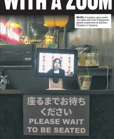  ?? ?? HI-FI: A hostess who works via video link from Philippine­s greets customers at Sansan Chicken in Queens.