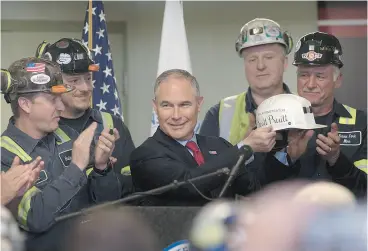  ?? JUSTIN MERRIMAN / GETTY IMAGES FILES ?? U. S. EPA Administra­tor Scott Pruitt holds up a miner’s helmet that he was given after speaking with coal miners at the Harvey Mine on April 13 in Sycamore, Pa.