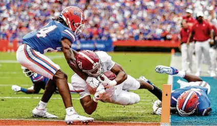  ?? James Gilber t / Getty Images ?? Alabama’s Jase McClellan dives for a touchdown during the first quarter against Florida on Saturday. The Crimson Tide never trailed en route to a 31-29 victory at Ben Hill Griffin Stadium.