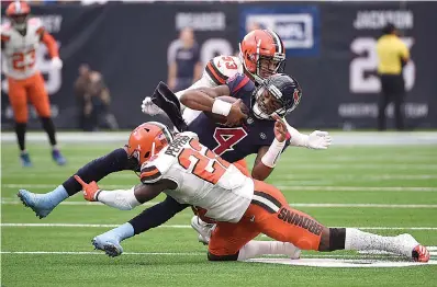  ?? AP Photo/Eric Christian Smith ?? ■ Houston Texans quarterbac­k Deshaun Watson (4) is hit by Cleveland Browns free safety Jabrill Peppers (22) and middle linebacker Joe Schobert (53) during the first half of an NFL football game Dec. 2 in Houston.