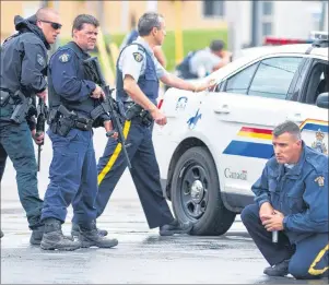  ?? CP PHOTO ?? Police keep watch on a house as they search for a heavily armed gunman following the shooting of three Mounties in Moncton, N.B., on June 5, 2014. The RCMP was fined $550,000 Friday for Labour Code violations in the 2014 Moncton, N.B., shooting rampage...