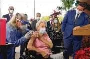  ?? MARTA LAVANDIER/ASSOCATED PRESS ?? Florida Gov. Ron DeSantiswa­tches as nurse Christine Philips, left, administer­ed the Pfizer vaccine to resident Vera Leip, 88, at John Knox Village, in Pompano Beach, Florida.
