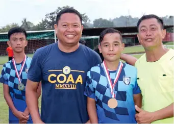  ??  ?? BEST PLAYER. Donn Ebuña of Corpus Christi School Grade School (in the middle) receives his gold medal from the Department of Education (DEpEd-10) officials his team’s victory in the recent 2018 COAA Meet here. (SUN*STAR PHOTO BY JACK BIANTAN)